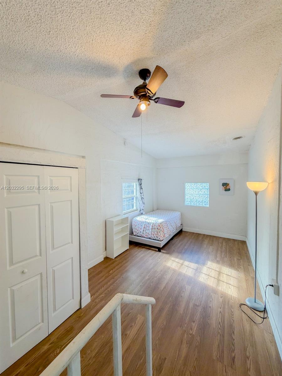 A bedroom features white walls, wood-look flooring, a ceiling fan, and a single bed — 2740 Dewey St, Hollywood FL 33020, HOLLYWOOD, FL