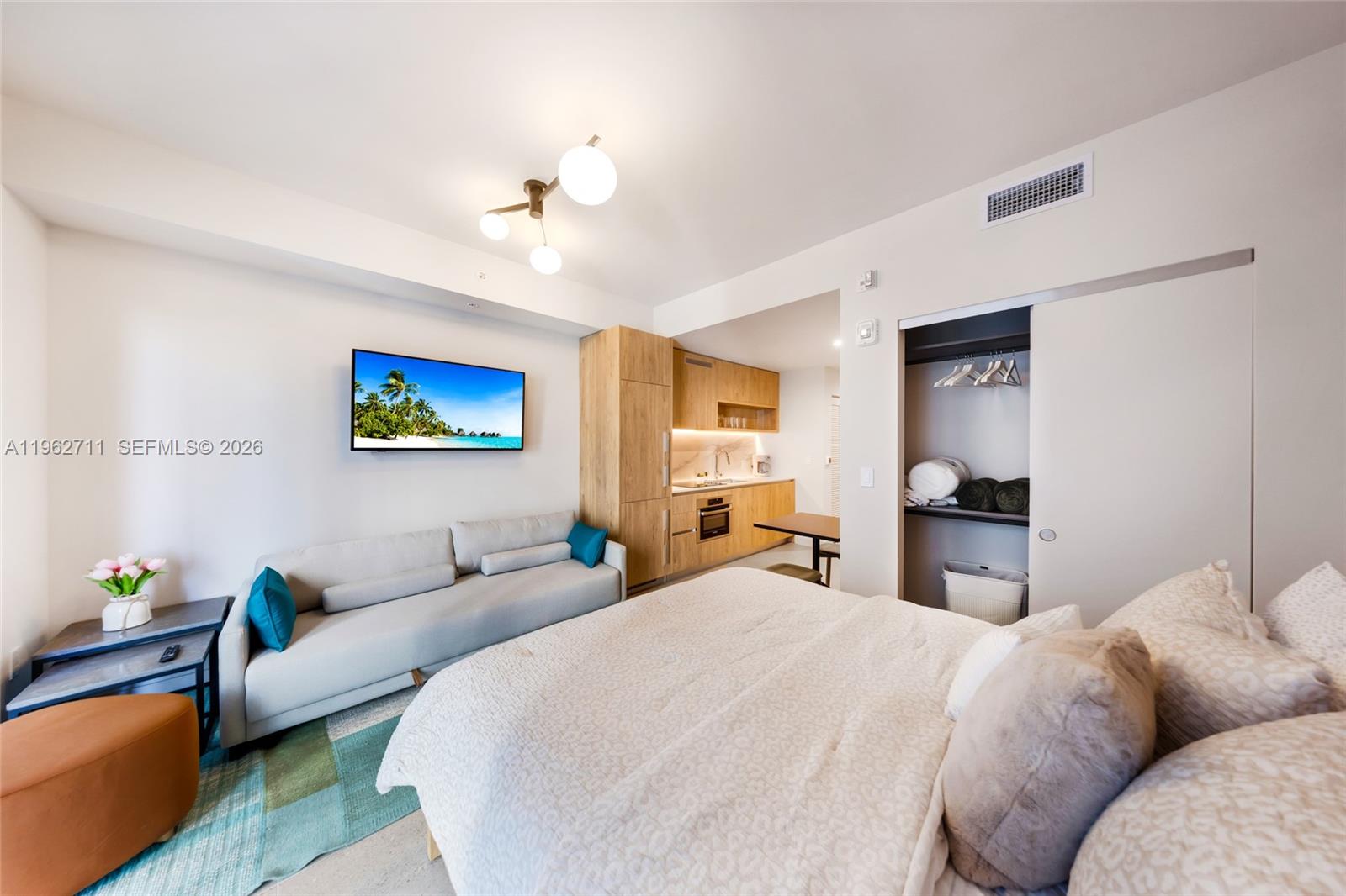 A studio apartment features a bed, sofa, kitchenette, and a closet with sliding doors — 11 NE 6th St # 1208, Miami FL 33132, MIAMI, FL