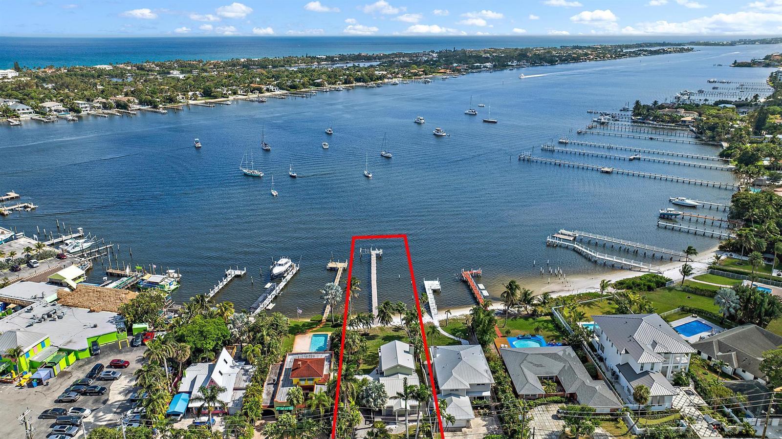 An aerial view shows a waterfront property with a private dock extending into the bay — 122 S Lake Drive, Lantana FL 33462, LANTANA, FL