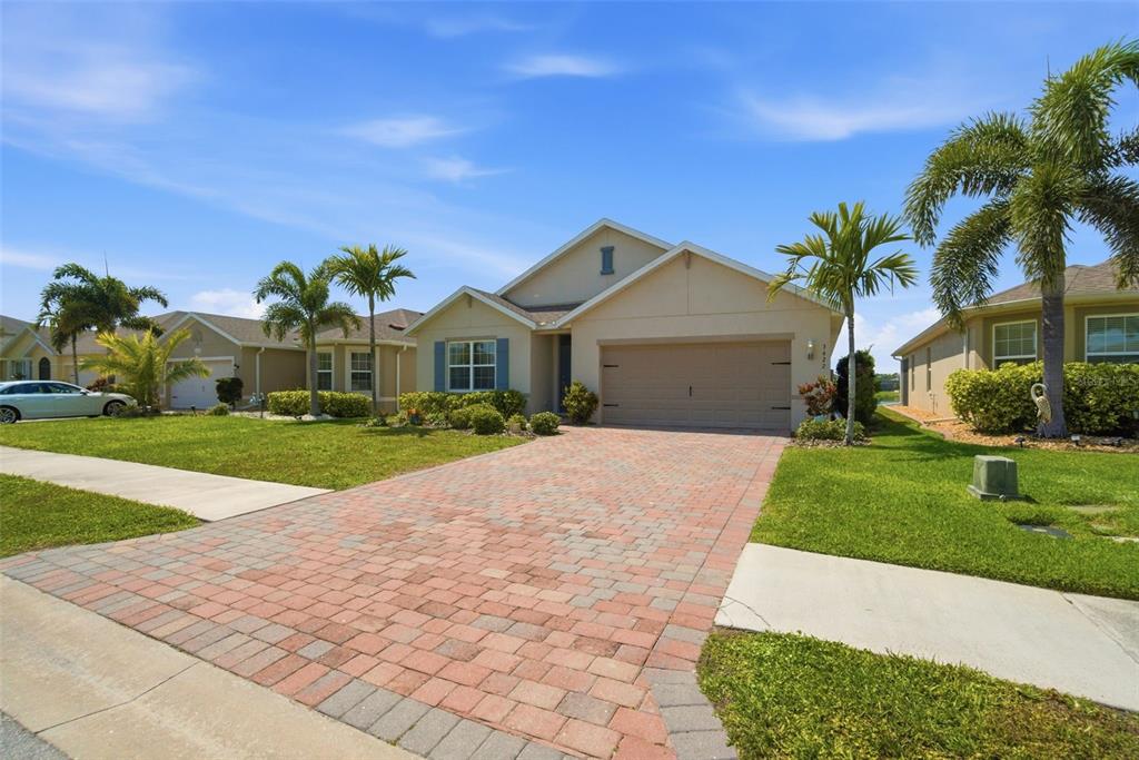 A single-story house with a brick paver driveway, a two-car garage, and palm trees — 3422 CANCUN COURT, CAPE CORAL, FL