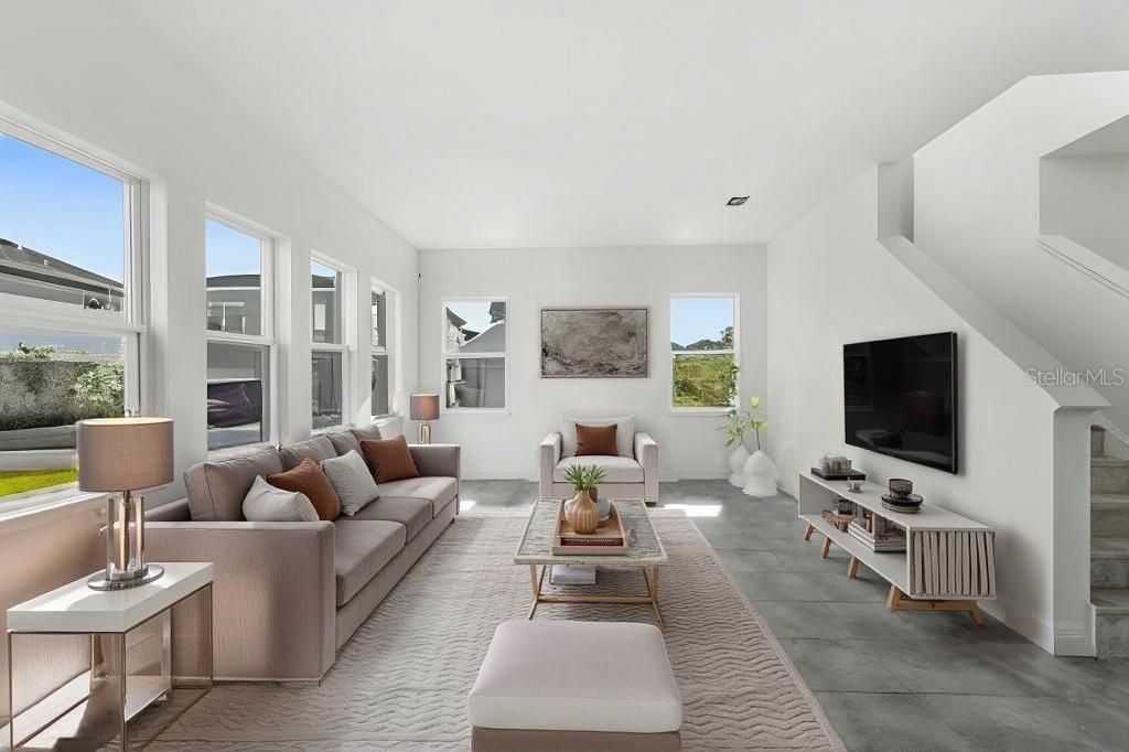 A modern kitchen features white cabinetry, stainless steel appliances, a central island, and gray tile flooring — 10133 PEEBLES STREET, ORLANDO, FL