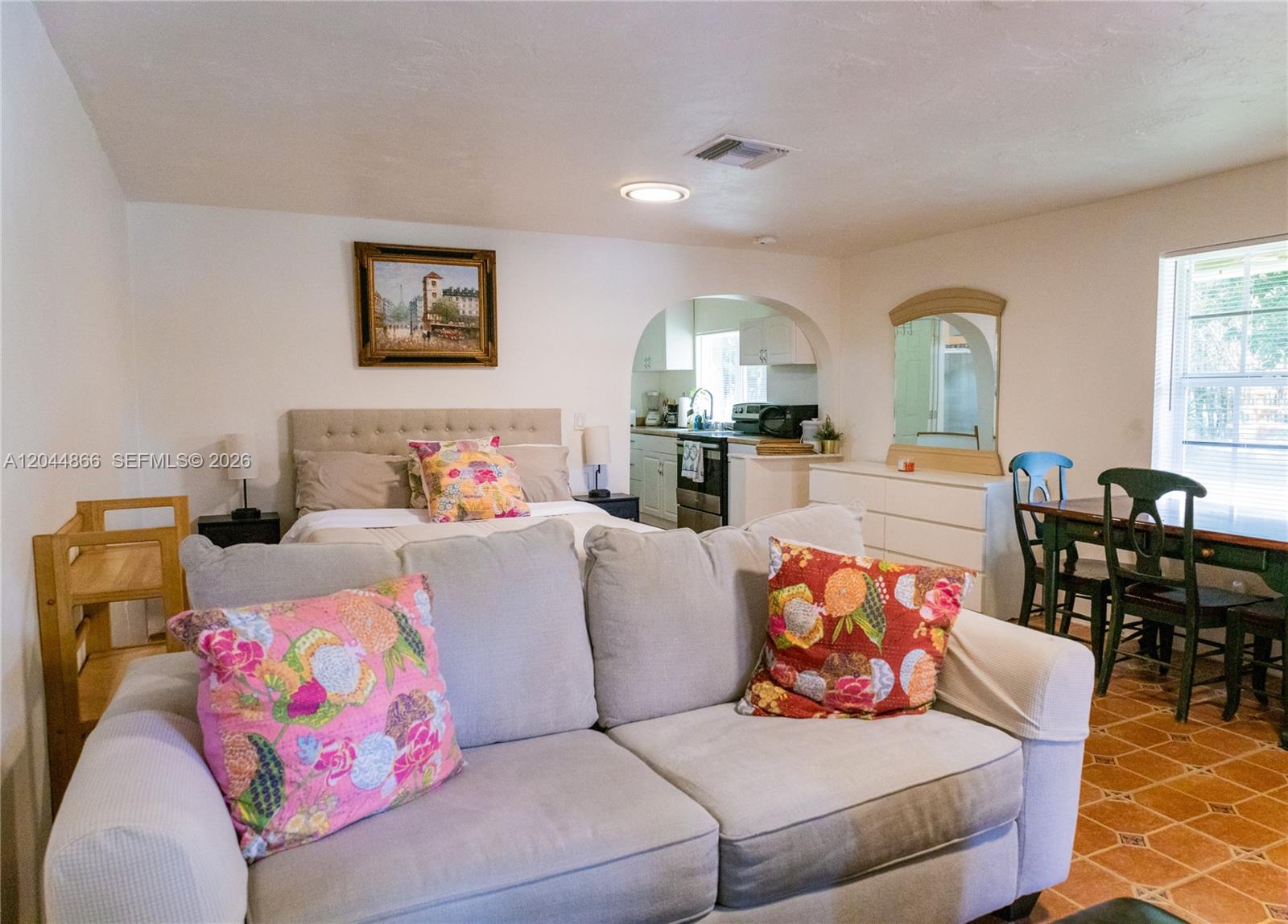 A studio apartment features a bed, sofa, dining area, and an arched kitchen entrance — 271 NE 154th St # 1, Miami FL 33162, MIAMI, FL