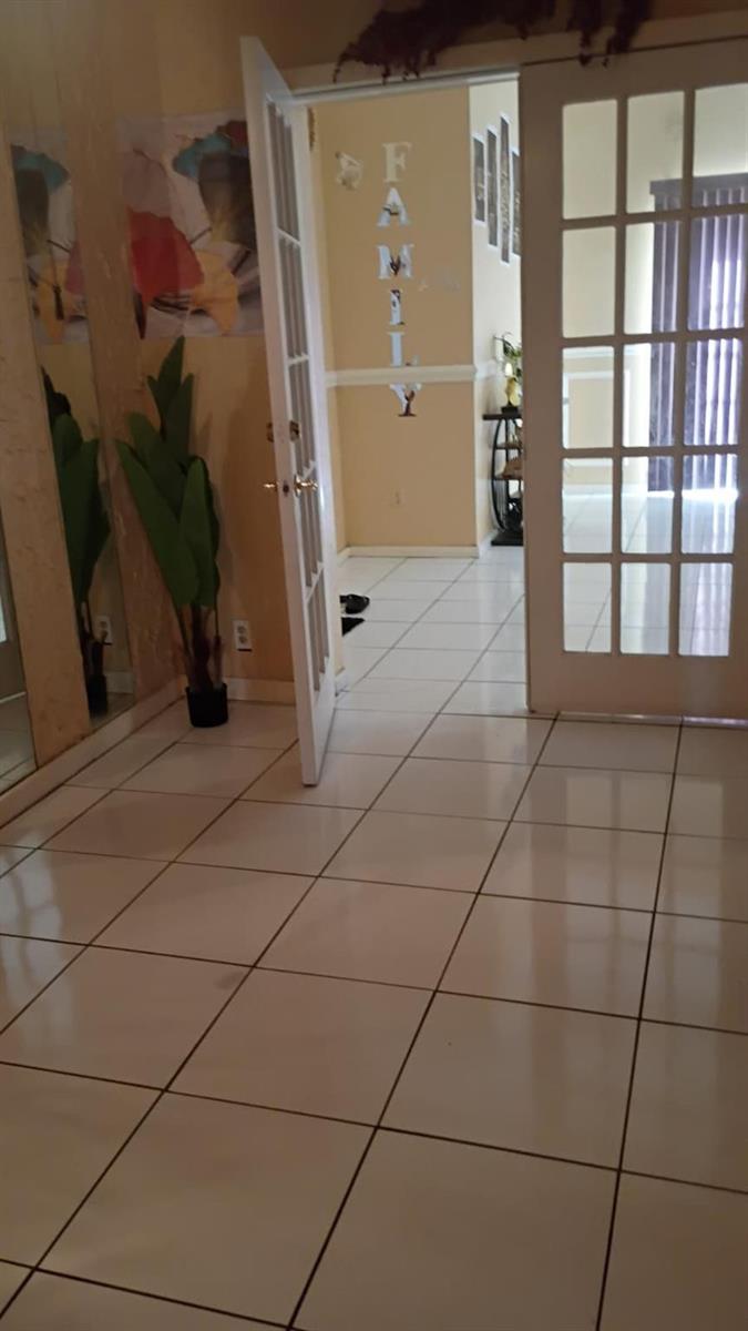 A tiled entryway leads through a glass-paneled door into a hallway with "FAMILY" wall lettering — 336 NW 7th Court, Deerfield Beach FL 33441, DEERFIELD BEACH, FL