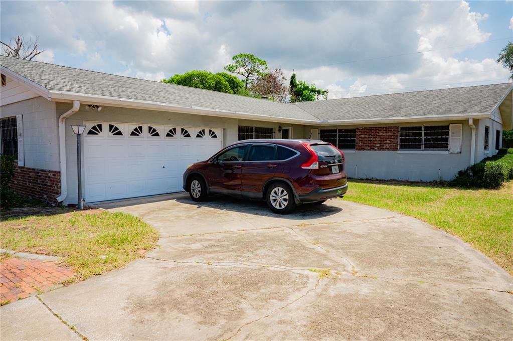 A single-story house with a white garage door and a maroon SUV in the driveway — 2705 SHERINGHAM ROAD UNIT 6, ORLANDO, FL