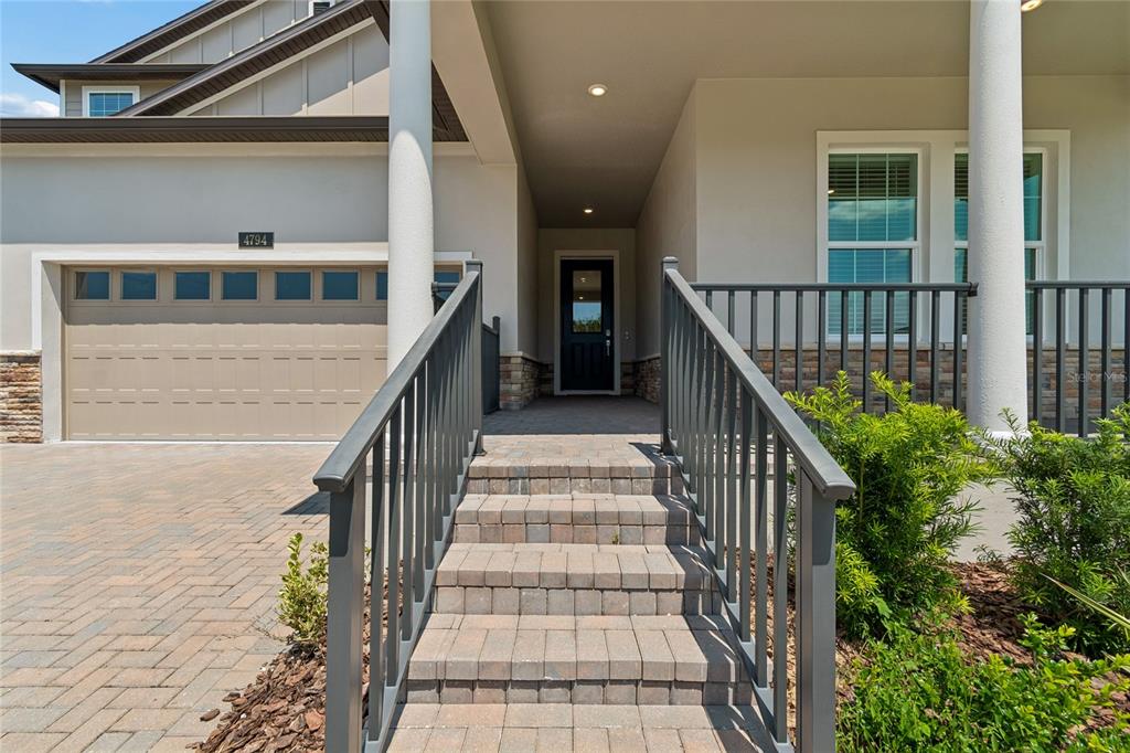 A paved walkway with steps leads to the front entrance of a house with a garage — 4794 SOUTHERN VALLEY LOOP, BROOKSVILLE, FL