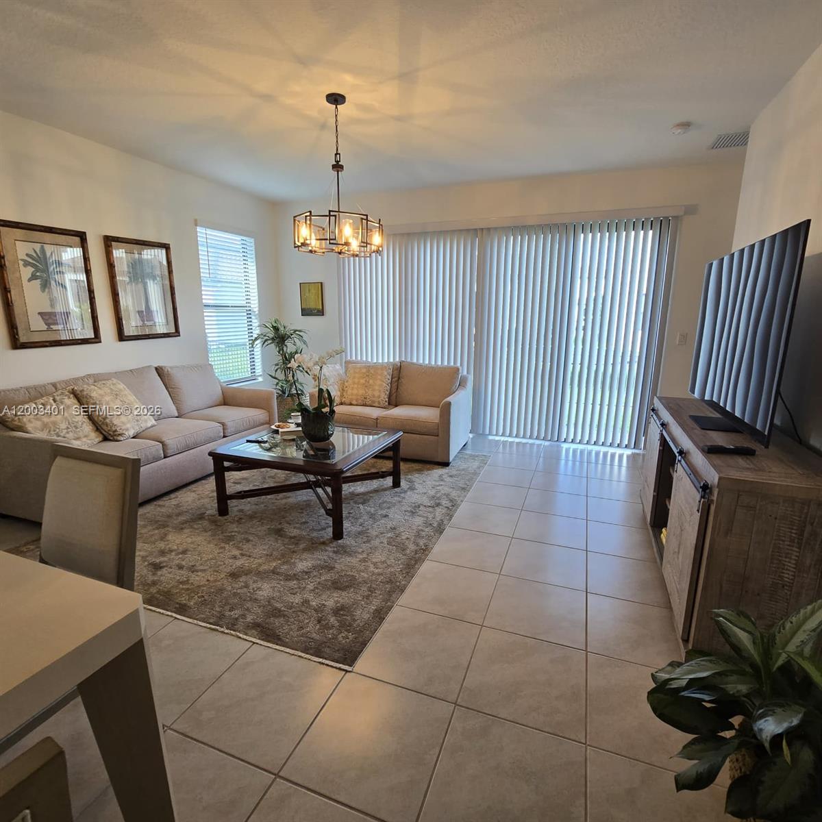 A living room features a beige sofa, a glass-top coffee table, and tile flooring — 5615 CARRARA DR, Ave Maria FL 34142, AVE MARIA, FL