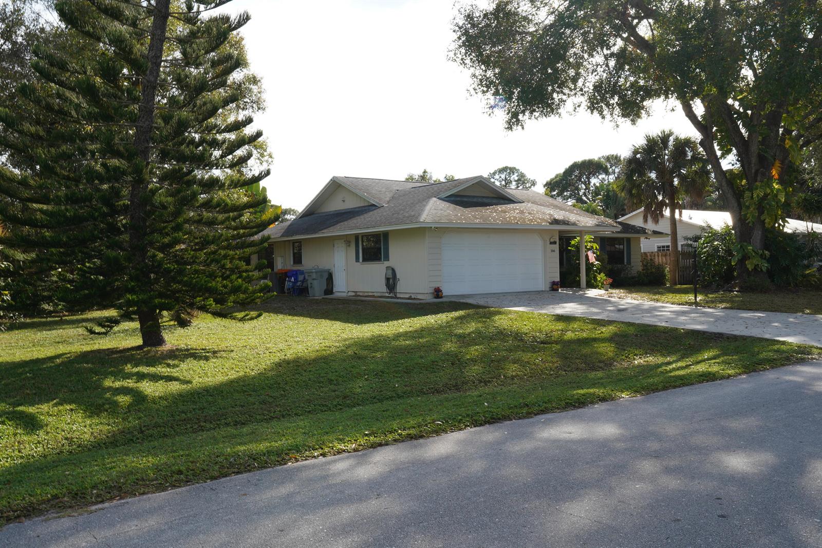 A single-story house with a white garage, light siding, and a large front lawn — 166 23rd Avenue, Vero Beach FL 32962, VERO BEACH, FL