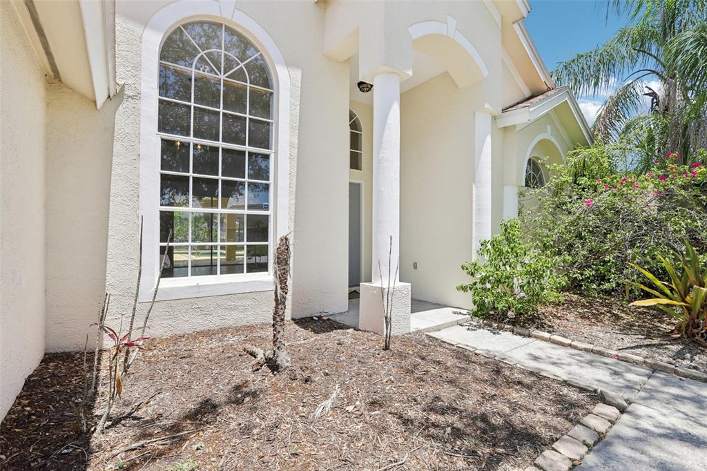 The exterior of a house features a large arched window, white columns, and a walkway — 9029 WESTBAY BOULEVARD, TAMPA, FL