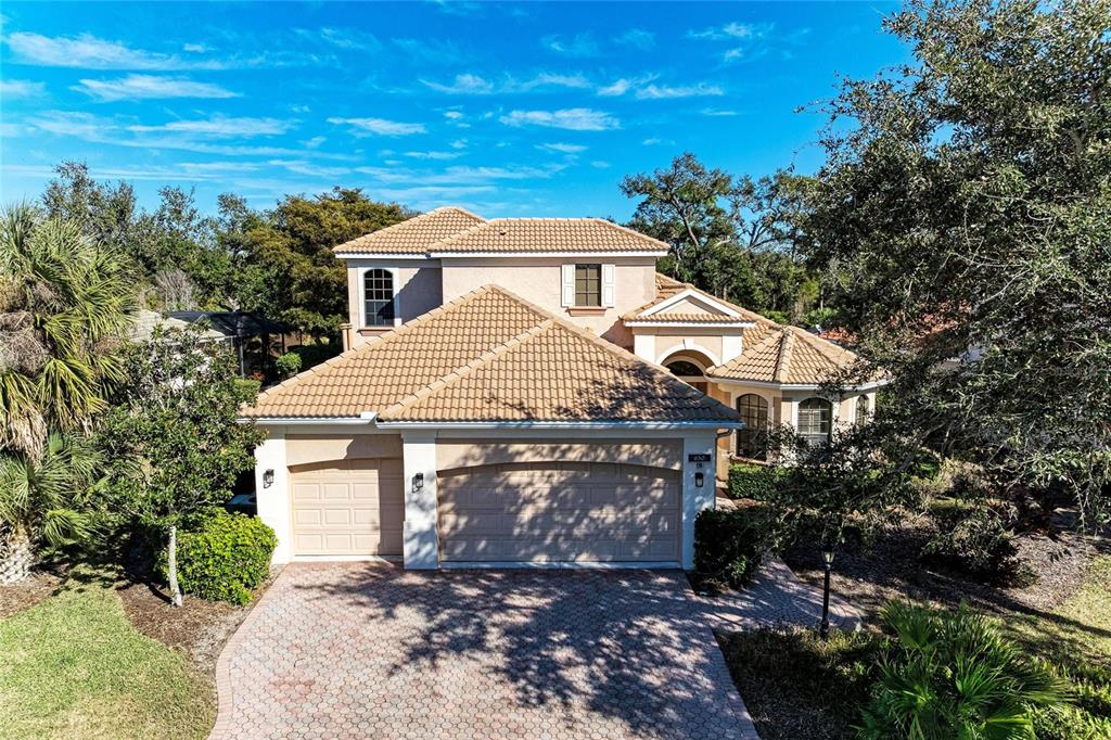 A two-story stucco house with a tile roof and a three-car garage — 650 CRANE PRAIRIE WAY, OSPREY, FL