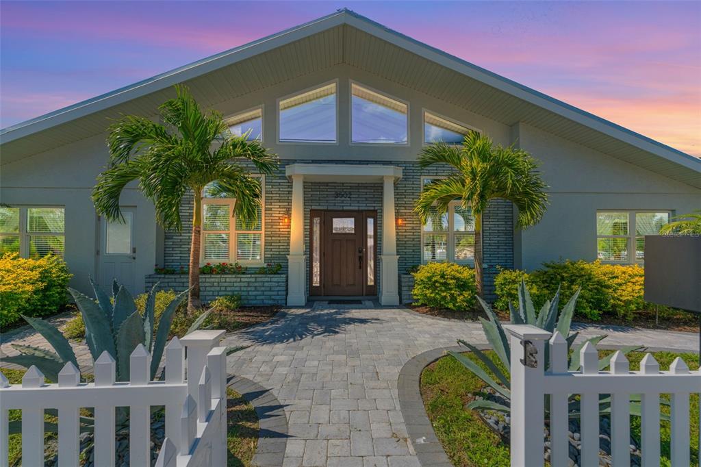 A single-story house with a gabled roof, brick facade, and a white picket fence — 3502 BAHIA VISTA STREET, SARASOTA, FL
