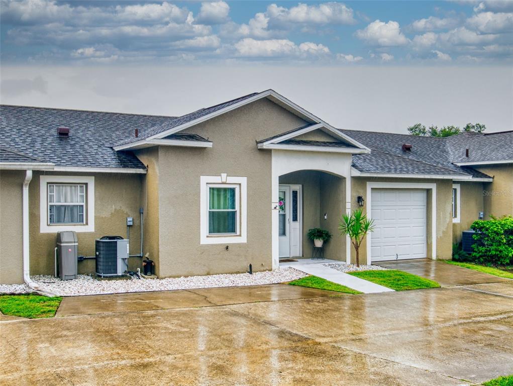 A bright entryway features white walls, tiled floors, a front door with sidelight, and vaulted ceilings — 242 PINE BLUFF AVENUE UNIT 242, DELAND, FL