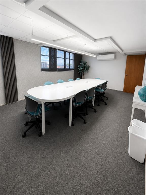 A conference room features a long white table, gray carpet, and a wall-mounted air conditioner — Calle 30 CAPARRA TERRACE SO1300, CAPARRA TERRACE, PR
