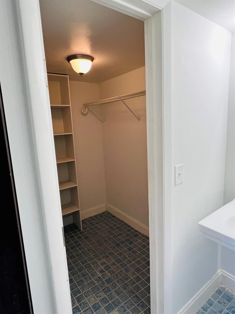 A walk-in closet features white shelving, a wire hanging rod, and blue tiled flooring — 614 NW 13th Street # 0280, Boca Raton FL 33486, BOCA RATON, FL