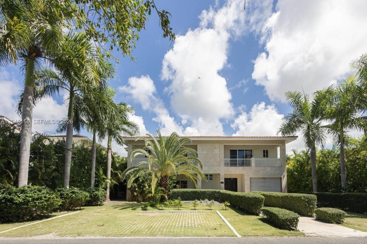 A two-story house with a stone facade, a balcony, and palm trees in the yard — 0 cocotal, FL