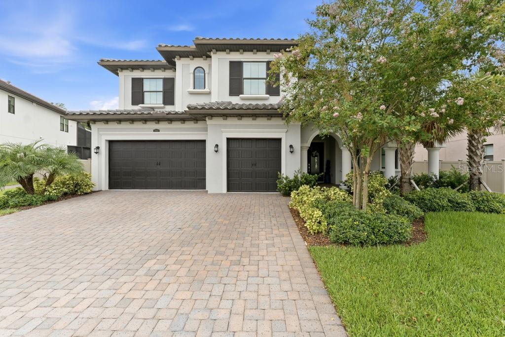 A two-story house with a paver driveway, a three-car garage, and a landscaped front yard — 29818 PICANA LANE, WESLEY CHAPEL, FL