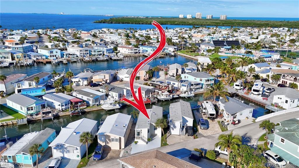 An aerial view shows a waterfront mobile home community with a red arrow pointing downward — 1092 Nettles Boulevard, Jensen Beach FL 34957, JENSEN BEACH, FL