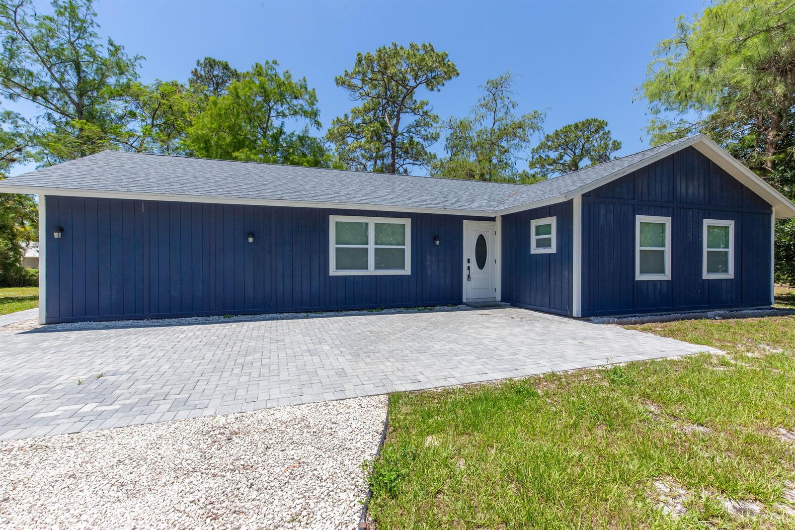 A blue, single-story house with a white front door and a paved driveway — 16932 W Aintree Drive W, Loxahatchee FL 33470, LOXAHATCHEE, FL
