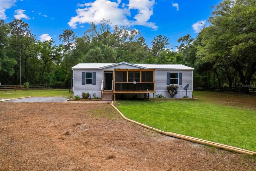 A single-story manufactured home features a screened-in front porch and a metal roof — 7360 SW 157TH LANE, DUNNELLON, FL