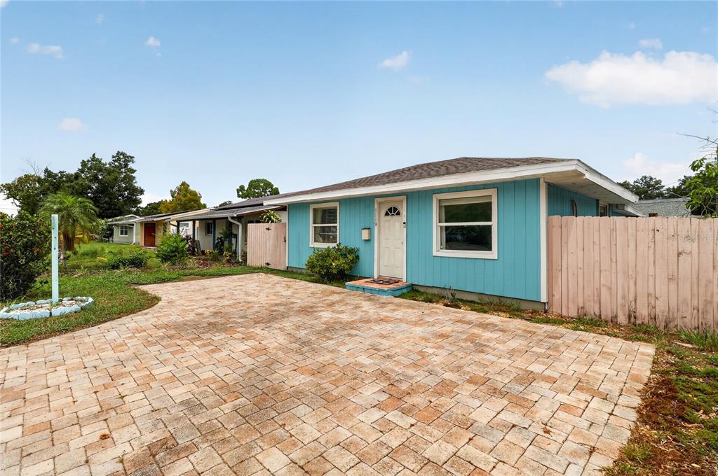 A single-story blue house with a paved driveway and a wooden fence — 1119 54TH AVENUE N, ST PETERSBURG, FL