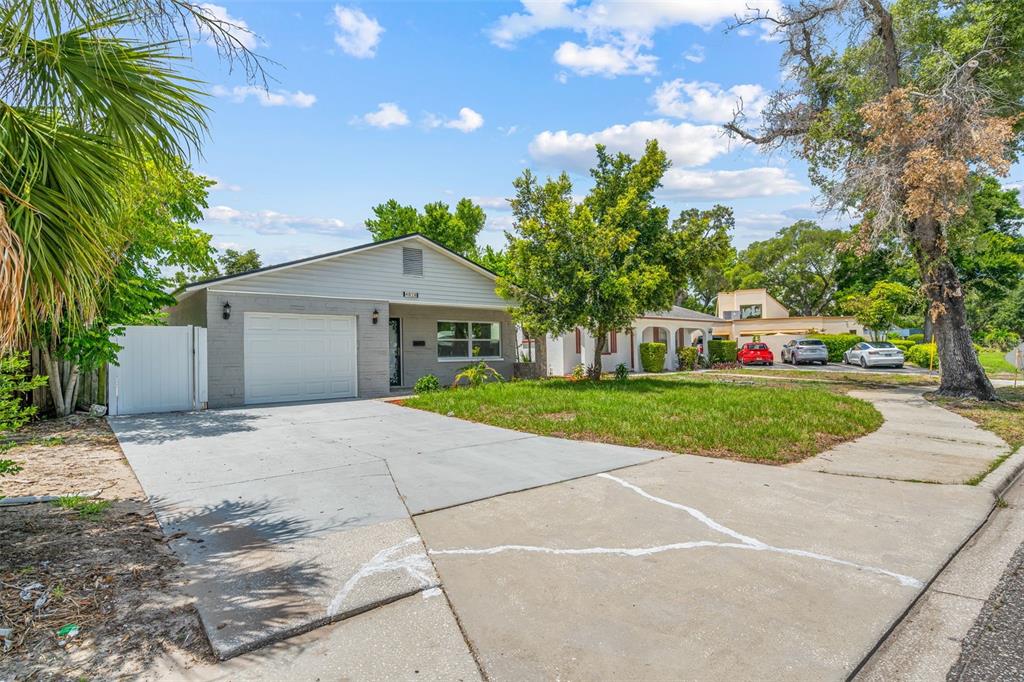 A single-story gray house with a garage and driveway sits on a grassy lot — 4828 22ND AVENUE N, ST PETERSBURG, FL