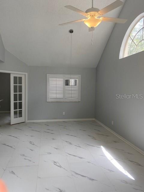 An empty room features white marble-look tile flooring, a ceiling fan, and a pendant light — 575 BLOOMINGTON COURT UNIT 20, ALTAMONTE SPRINGS, FL