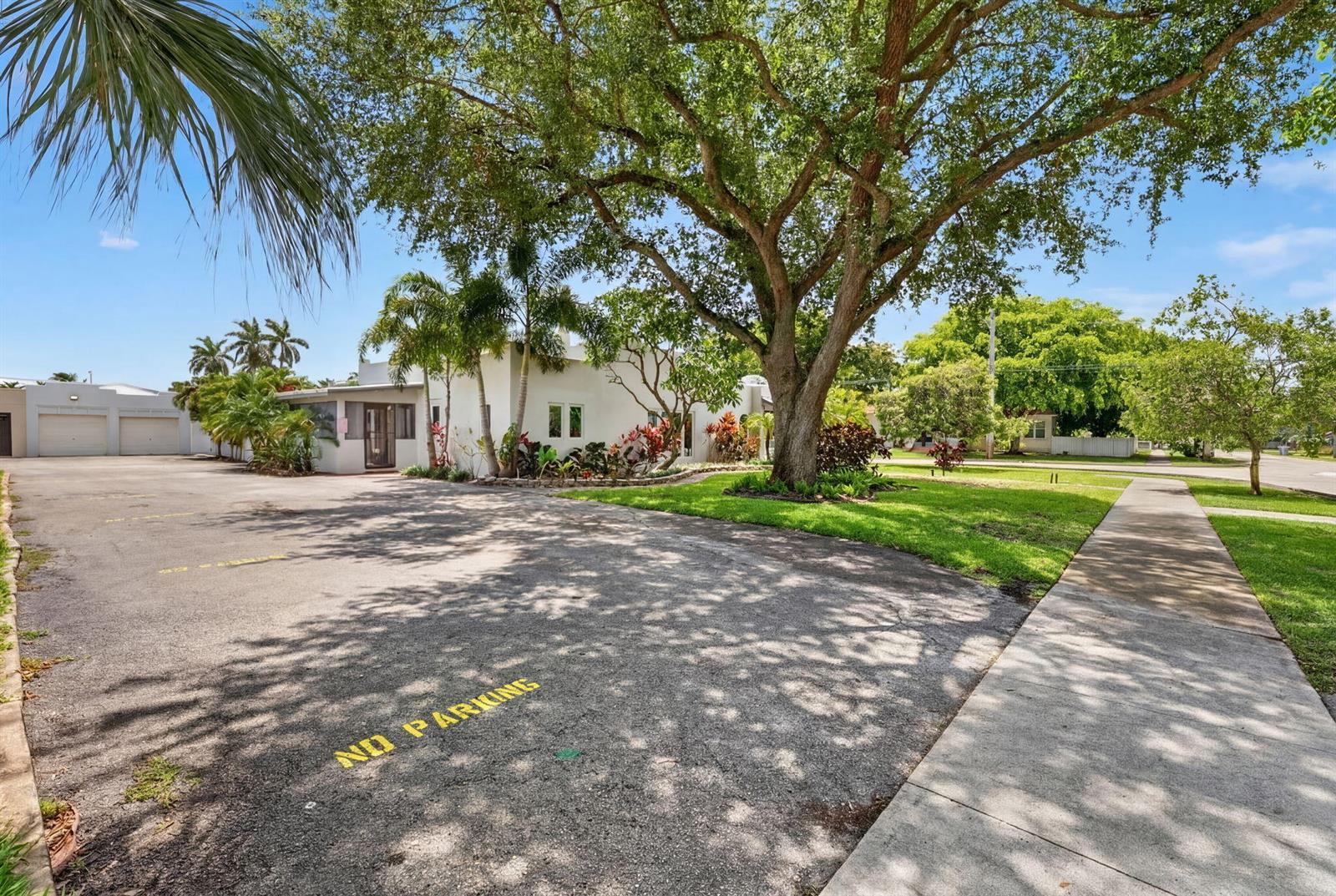 A white building with a large tree and a paved parking lot in front — 400 NE 5th Avenue, Pompano Beach FL 33060, POMPANO BEACH, FL