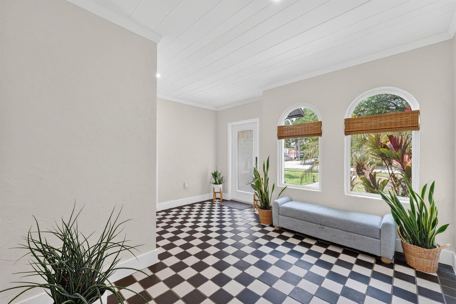 A bright entryway features black and white checkered tile flooring, arched windows, and potted plants — 400 NE 5th Avenue, Pompano Beach FL 33060, POMPANO BEACH, FL