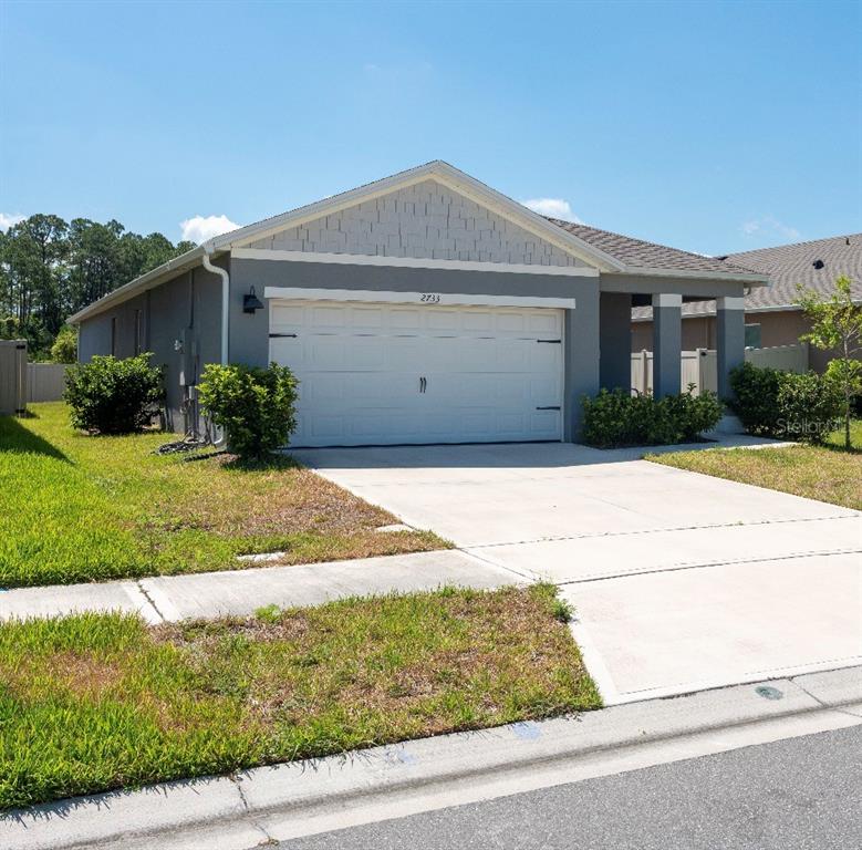 A single-story house with a gray exterior, a two-car garage, and a concrete driveway — 2733 REDDISH EGRET BEND, HARMONY, FL