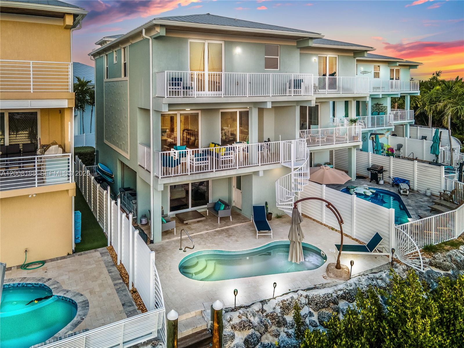 An aerial view of a multi-story house with balconies, a spiral staircase, and a pool — 443 Sombrero Beach Rd, Marathon FL 33050, MARATHON, FL