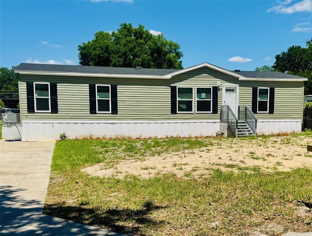 A single-story manufactured home with light green siding and a white foundation skirt — 389 WATERVIEW DRIVE, POLK CITY, FL
