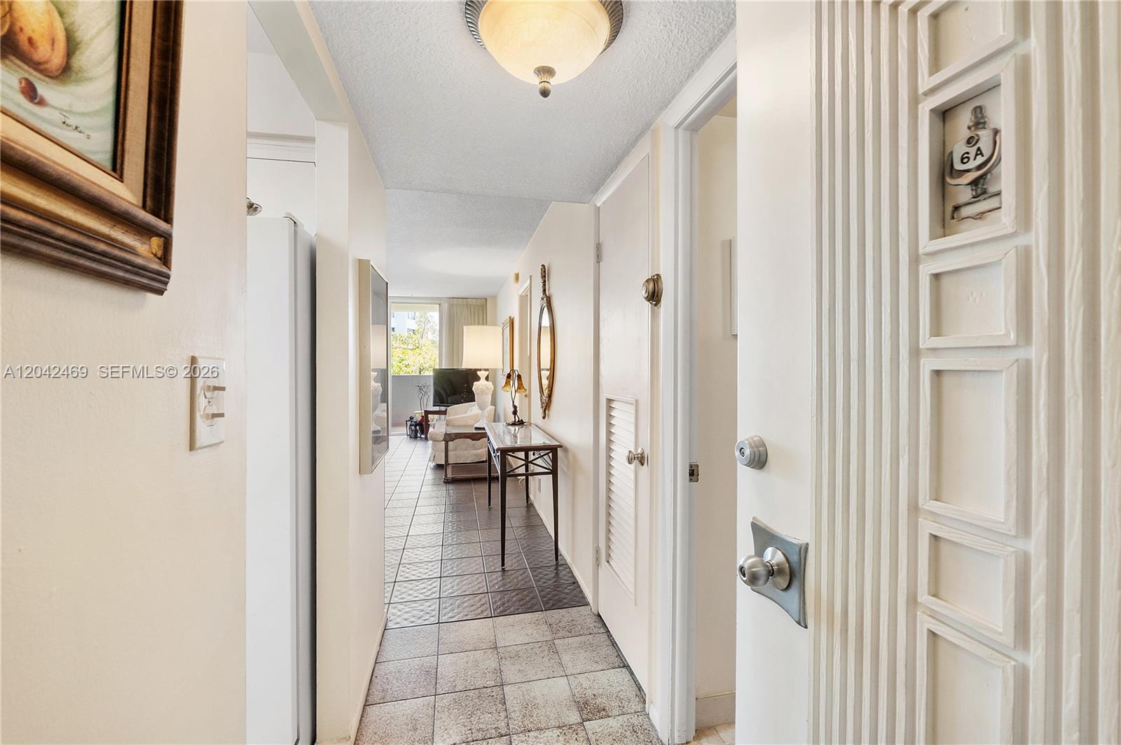 A tiled hallway leads from an entryway into a living area with a balcony — 5 Island Ave # 6A, Miami Beach FL 33139, MIAMI BEACH, FL