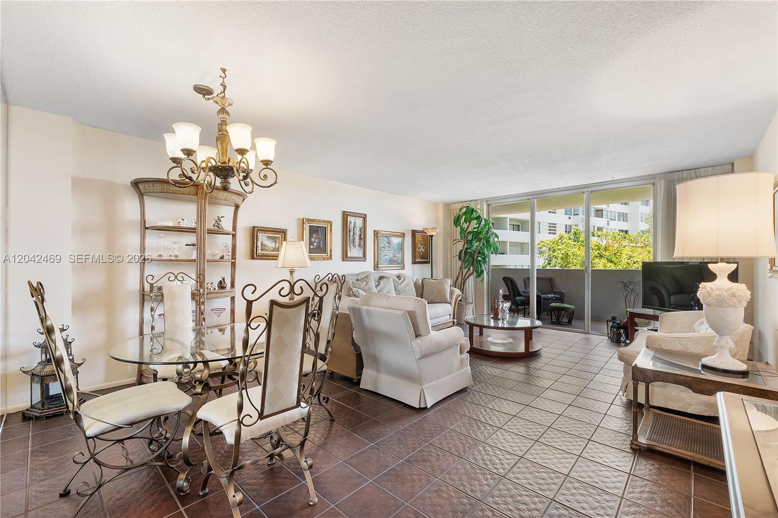 A living and dining area with tile floors, a glass table, and a balcony view — 5 Island Ave # 6A, Miami Beach FL 33139, MIAMI BEACH, FL