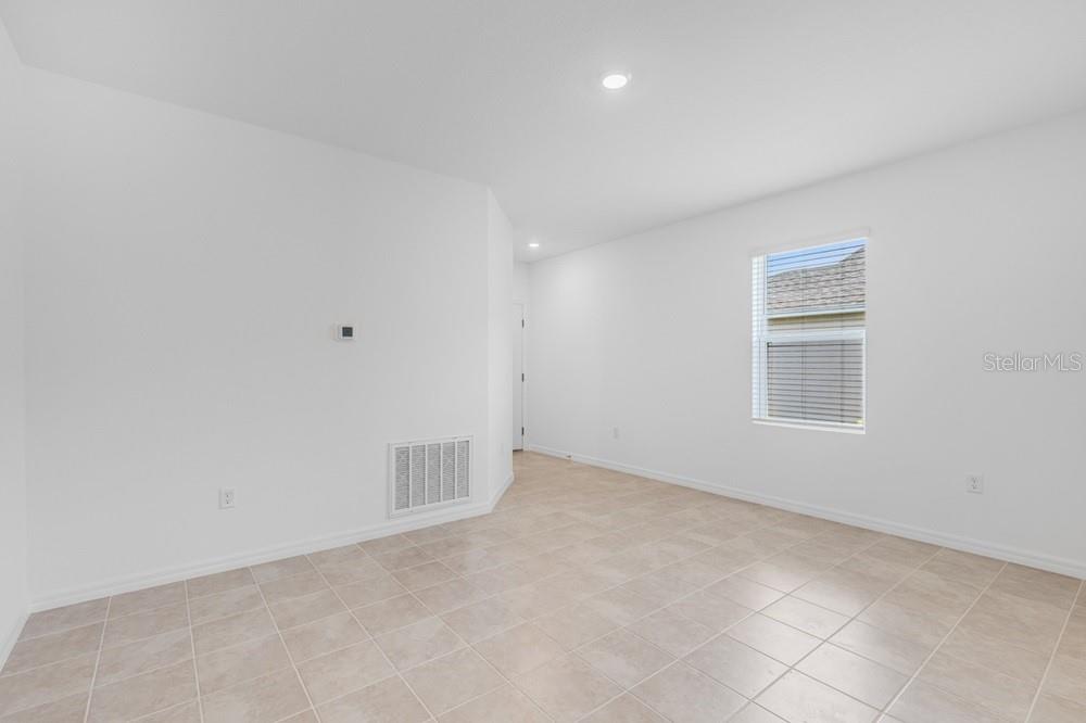 An empty room with white walls, tile flooring, and a single window — 13803 SHELLMORE AVENUE, PALMETTO, FL