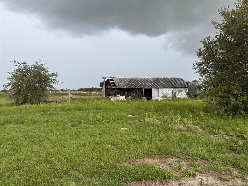 A weathered, partially collapsed barn sits in a grassy field under a cloudy sky — 4011 E ROBINSON DRIVE, HAINES CITY, FL