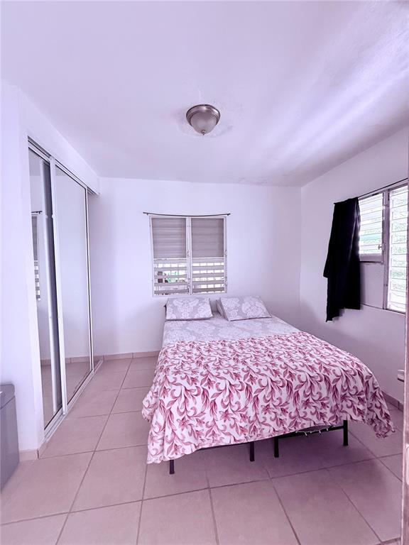 A kitchen with white cabinets, a breakfast bar with two stools, and tiled flooring — 181 ROUTE, YABUCOA, PR
