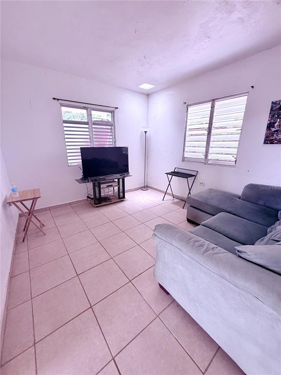 A hallway with tiled floors leads to multiple doorways and a kitchen with a refrigerator — 181 ROUTE, YABUCOA, PR