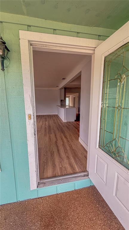A view through an open front door into a home with wood-look flooring — 5045 38TH AVENUE N, ST PETERSBURG, FL