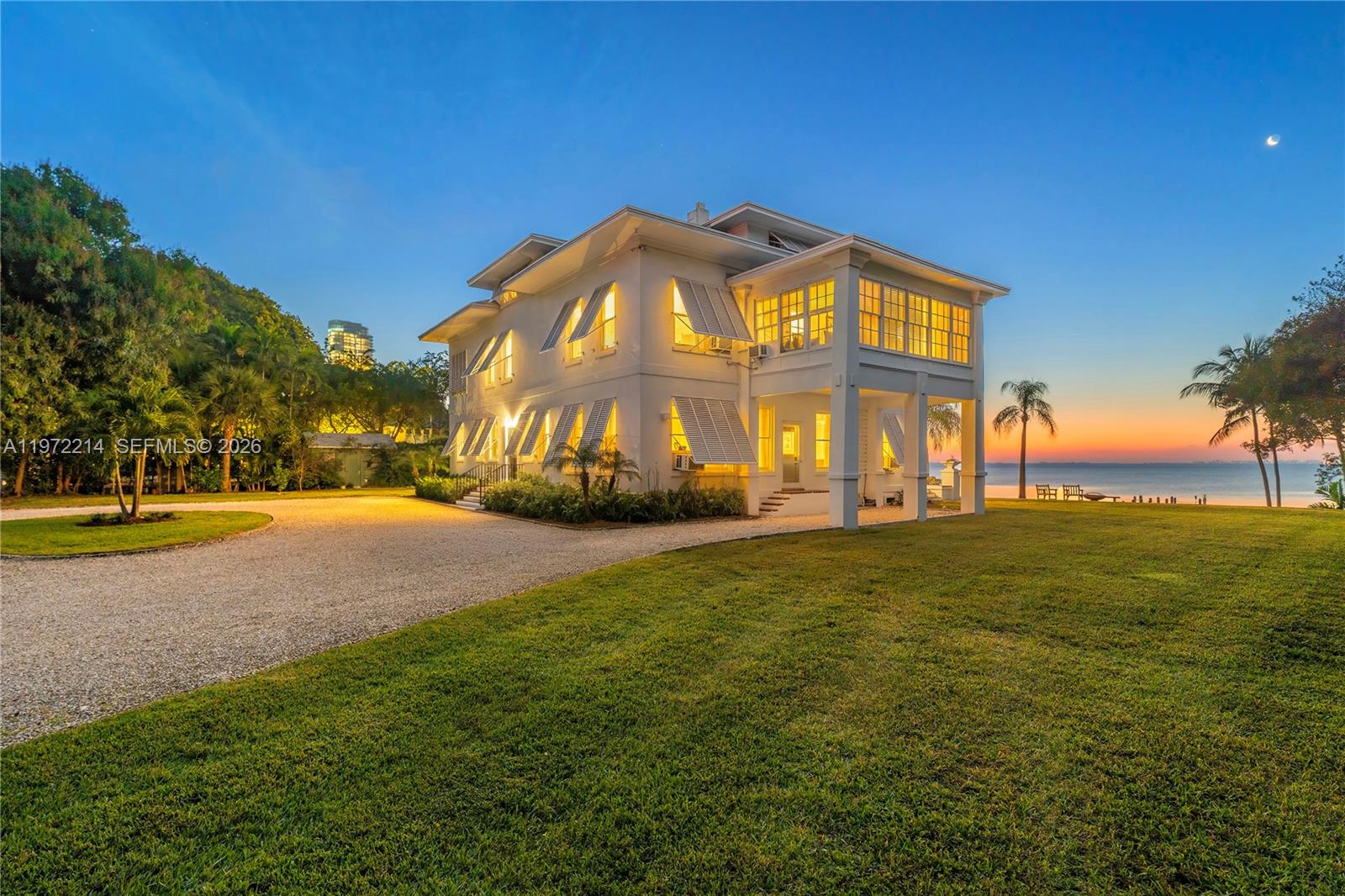 A white two-story house with shutters sits on a grassy lawn by the water — 3149 Brickell Ave, Miami FL 33129, MIAMI, FL