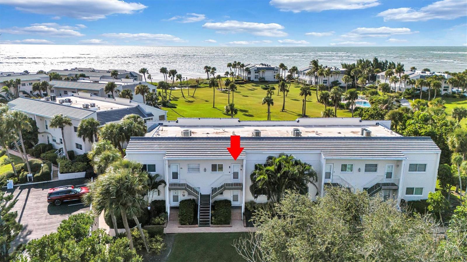 An aerial view shows a multi-story residential building with a red arrow pointing to a unit — 7125 Gulf Of Mexico # 22, FL 34228, FL