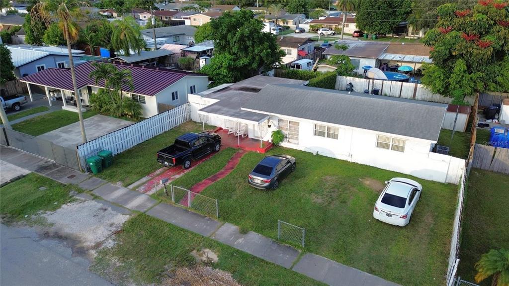 An aerial view shows a single-story house with a white exterior, a gray roof, and three cars — 30081 SW 148TH AVENUE, HOMESTEAD, FL