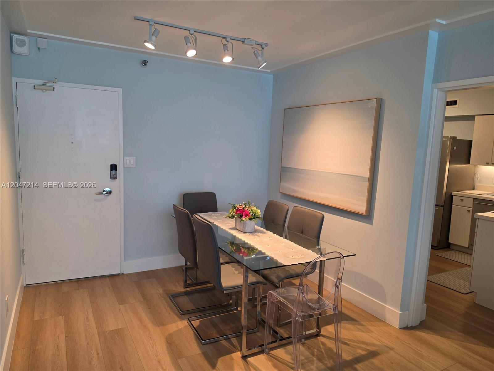 A dining area features a glass table, gray chairs, a clear chair, and track lighting — 5151 Collins Ave # 429, Miami Beach FL 33140, MIAMI BEACH, FL