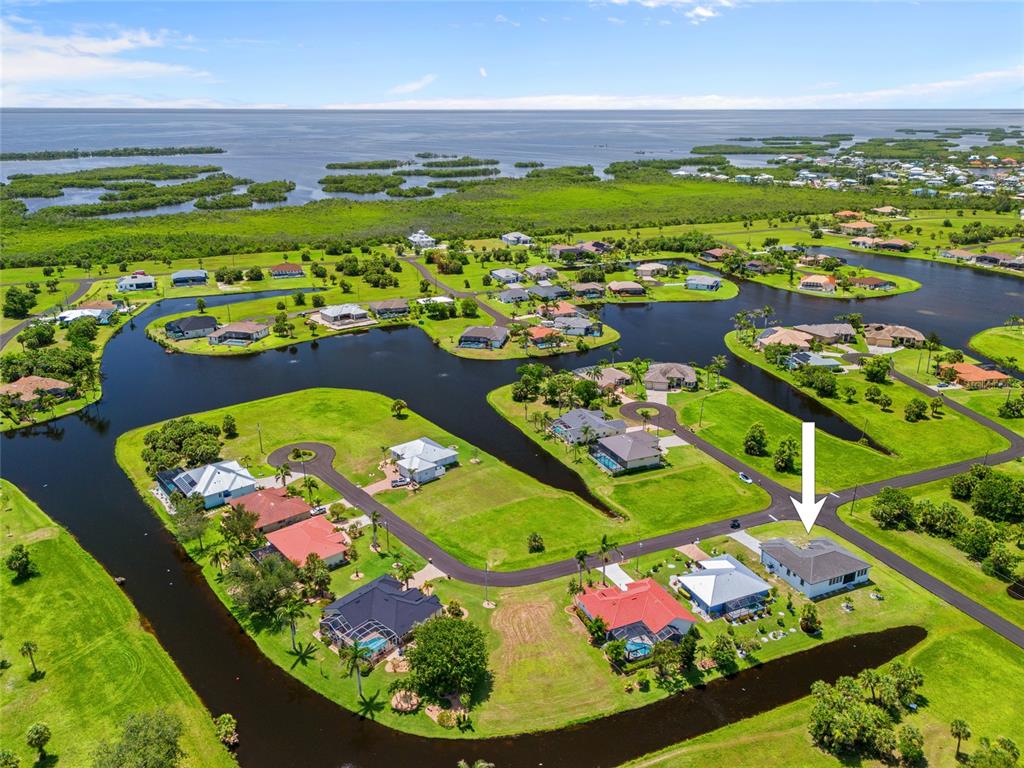 An aerial view shows a residential neighborhood with houses situated along a winding canal system — 16322 NOGALES COURT, PUNTA GORDA, FL