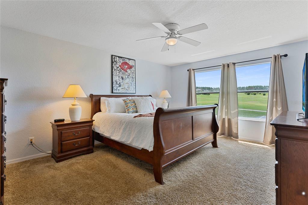 A bedroom features a wooden sleigh bed, two nightstands with lamps, and a large window — 606 BIRKDALE STREET, DAVENPORT, FL