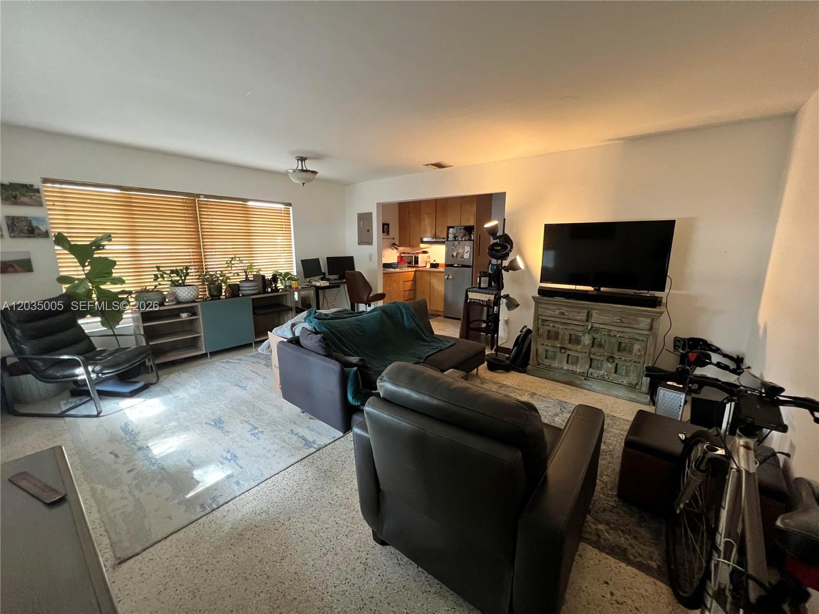 A living room features a sofa, leather armchair, television on a cabinet, and kitchen access — 8845 NE 8TH COURT # 2, Miami FL 33138, MIAMI, FL