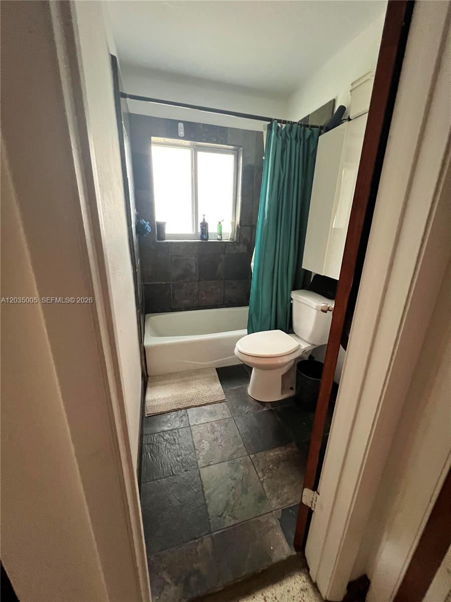 A small bathroom features a bathtub with dark tile walls and a white toilet — 8845 NE 8TH COURT # 2, Miami FL 33138, MIAMI, FL