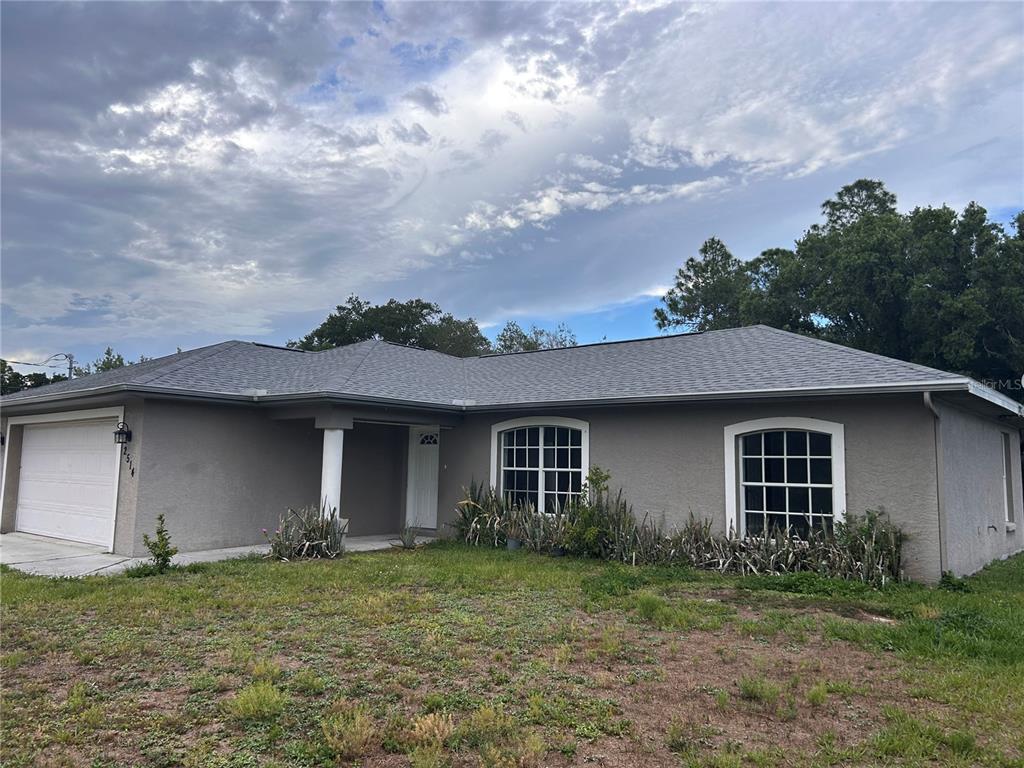 A single-story gray house with a two-car garage and two arched windows in front — 2514 AFFINITY LANE, NORTH PORT, FL
