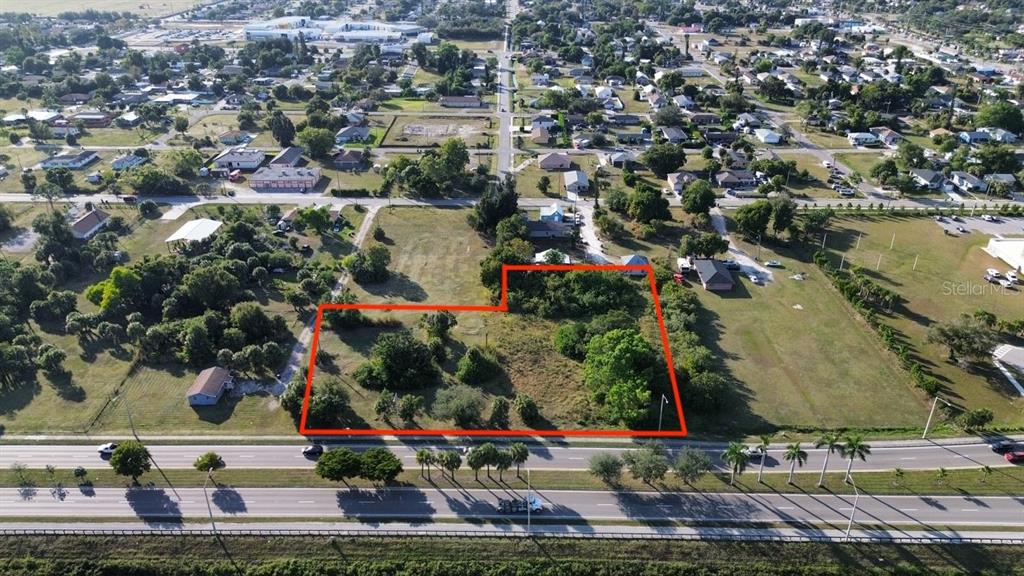 An aerial view shows a vacant, tree-covered lot outlined in red next to a road — 3550 S GRIMSLEY COURT, FORT MYERS, FL