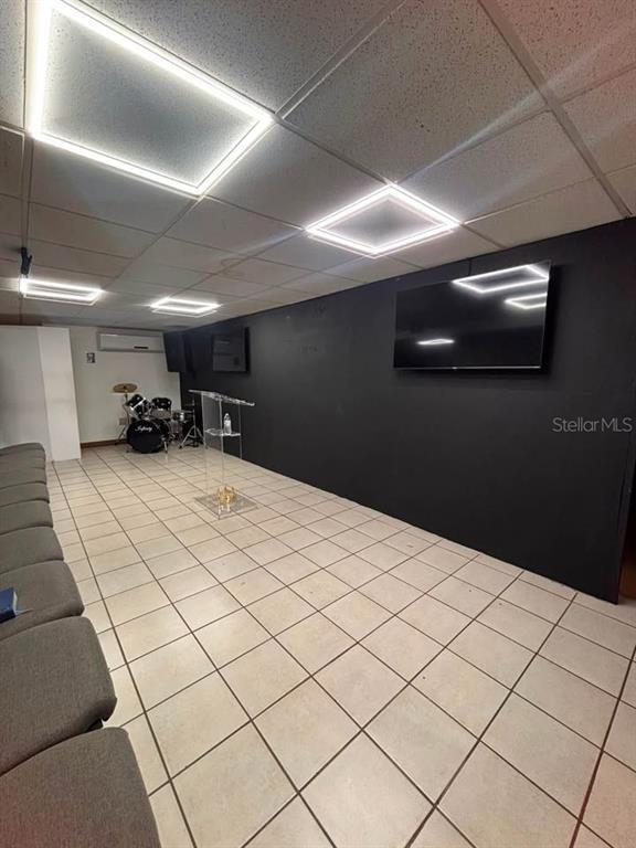 A room with a black accent wall, a television, a podium, and a drum set — 22 URB. RIVERVIEW AA1, CALLE 22, BAYAMON, PR