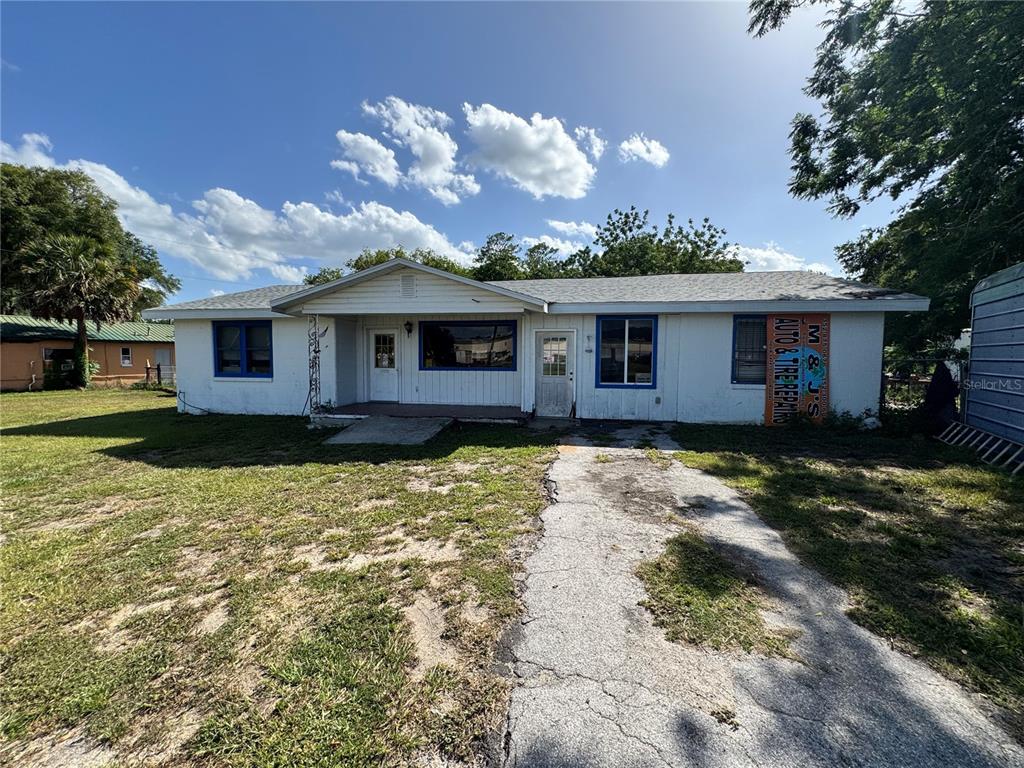 A single-story white building with blue trim and a paved driveway under a sunny sky — 5050 S PINE AVENUE, OCALA, FL
