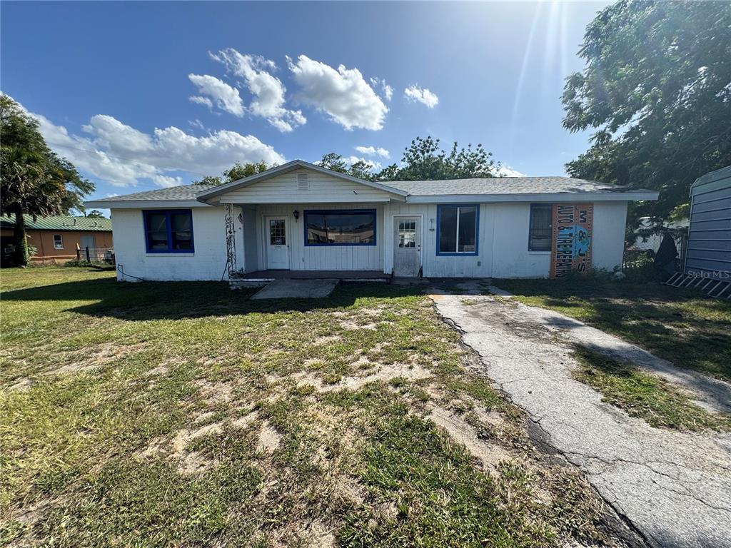 The exterior of a single-story white building with blue trim and a concrete driveway — 5050 S PINE AVENUE, OCALA, FL